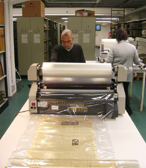 Arbeitsschritt: Die fertig laminierten Seiten werden aufgerollt und später passgenau geschnitten (Fotos: Christoph Albers, 16.12.2011) Arbeitsschritt: Die fertig laminierten Seiten werden aufgerollt und später passgenau geschnitten (Fotos: Christoph Albers, 16.12.2011)